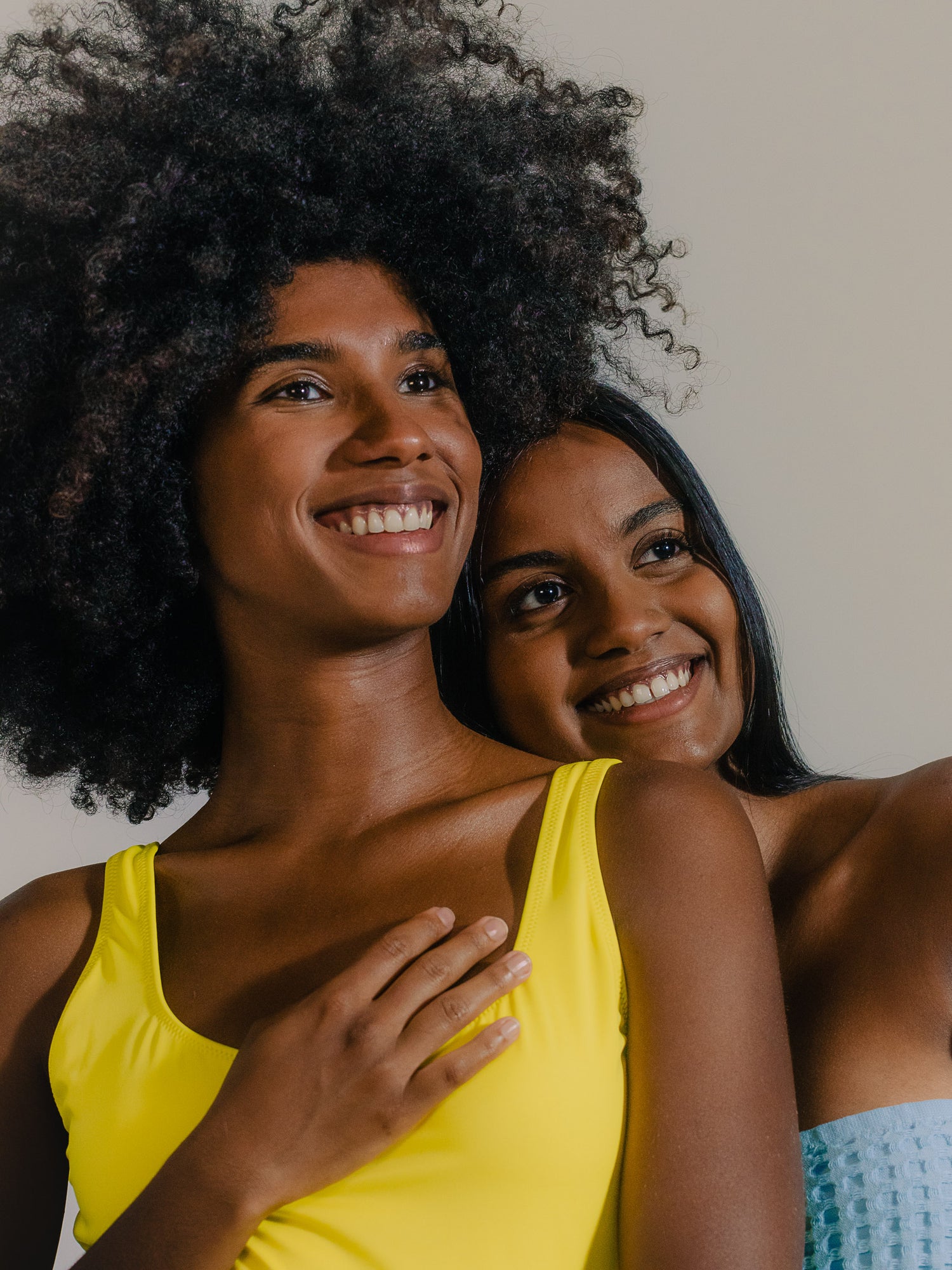 Two women smiling warmly, standing closely together